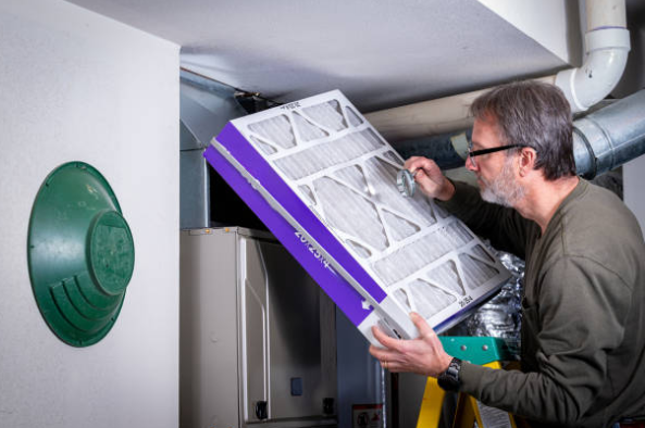 Homeowner Replacing Furnace Air Filter In Residential HVAC System