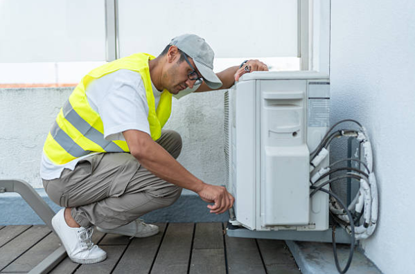 HVAC Technician Inspecting Outdoor Air Conditioning Unit On Balcony