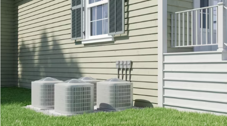 Multiple outdoor air conditioning condenser units installed beside a residential home for cooling system operation.