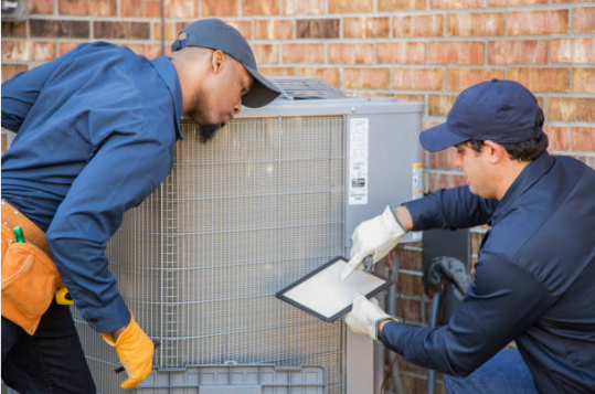 2 HVAC Technicians working on an outdoor unit.