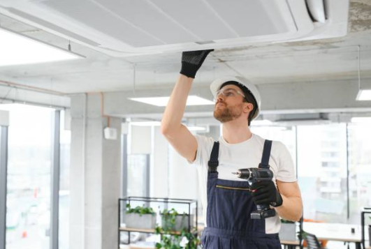 An HVAC technician wearing a vest and inspecting an Indoor Central AC