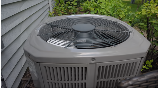 An outdoor HVAC condenser unit IS installed outside and surrounded by landscaping and greenery.